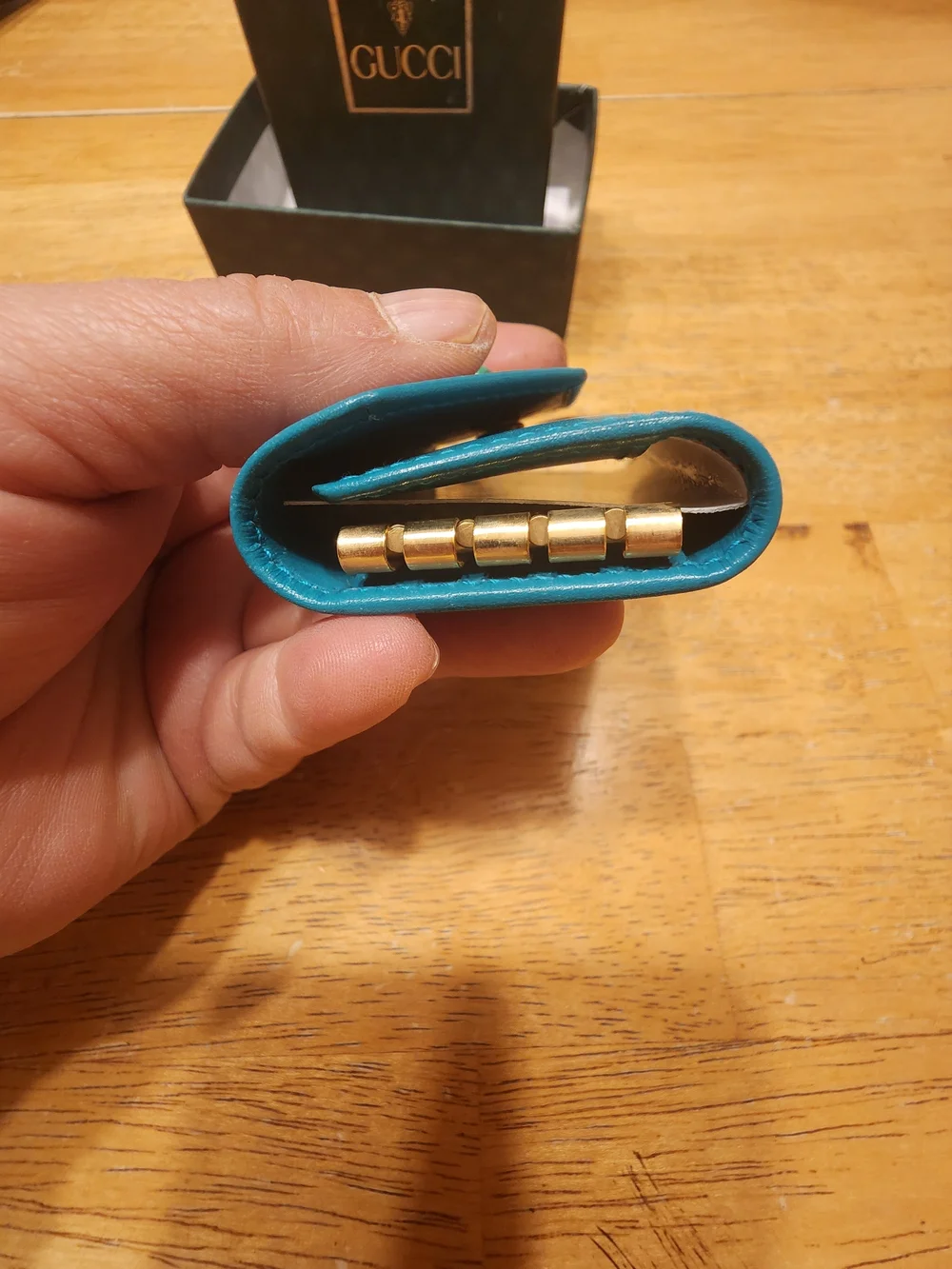 vintage Gucci teal leather key case featuring a distinctive cabochon stone